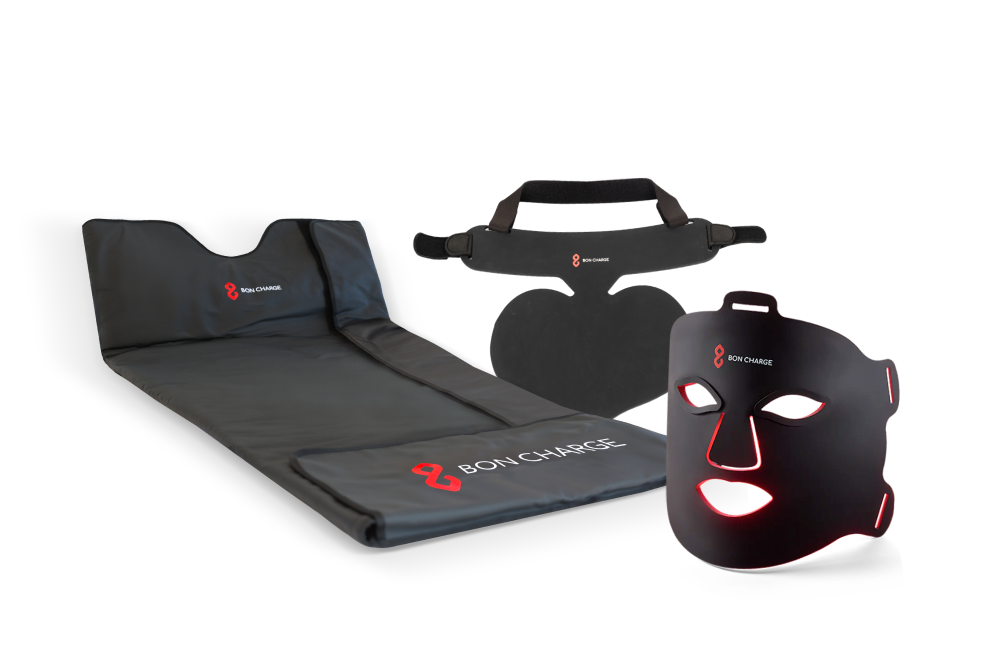 Glow Boost Kit Bundle, including neck and chest mask, sauna blanket and red light face mask switched on glowing red.